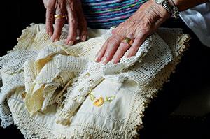 Frieda Pertman, 96, who lost her parents and six siblings to the Holocaust, displays her aunt’s more-than-100-year-old crocheted lace. At right, Frieda  at 26 in Russia with son Allan, daughter Rita and late husband Chaim.