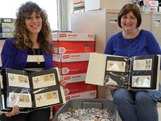 Special education teacher Janna Freishtat (left) and English teacher Cyndie Fagan have been instrumental in moving the Six Million Stamps Project forward. Shown here, they sit with a tub of thousands of stamps, many still waiting to be processed. (Photo by Melissa Gerr)
