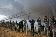 African migrants who are being held inside the Holot detention center stand at the fence as others who traveled to the site demonstrate against the detention center in the Negev Desert. (HEIDI LEVINE/SIPA/Newscom)