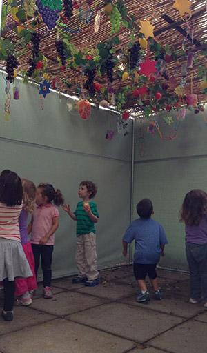 Preschoolers from the JCC help decorate a sukkah at Weinberg Park Assisted Living. (Provided)