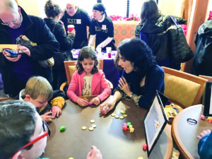 JCC interfaith engagement director Lara Nicolson plays dreidel with Ayelet Snyder at Foundry Row. (Photo by JCC)