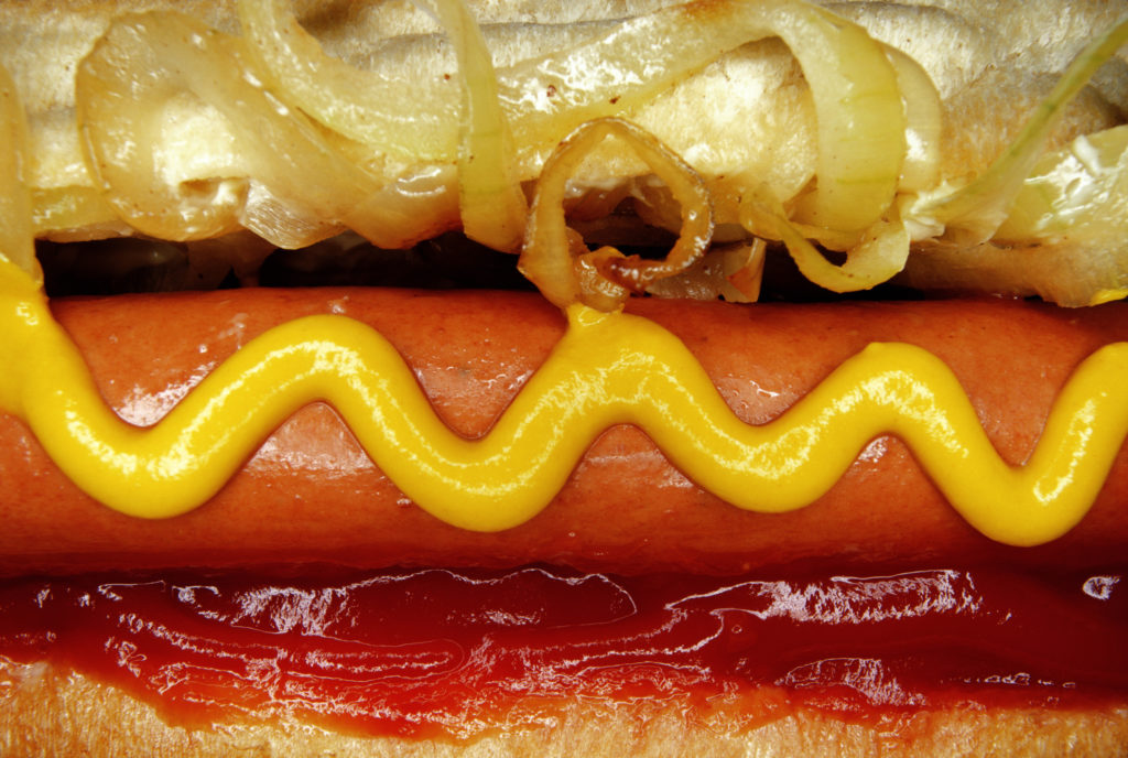 hot dog with ketchup, mustard, and onions